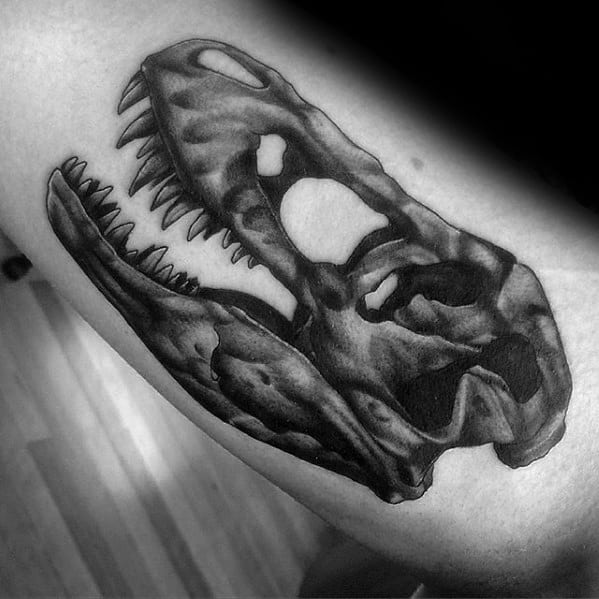 Inner Arm Bicep Dinosaur Skull Jurassic Park Tattoo Design On Man