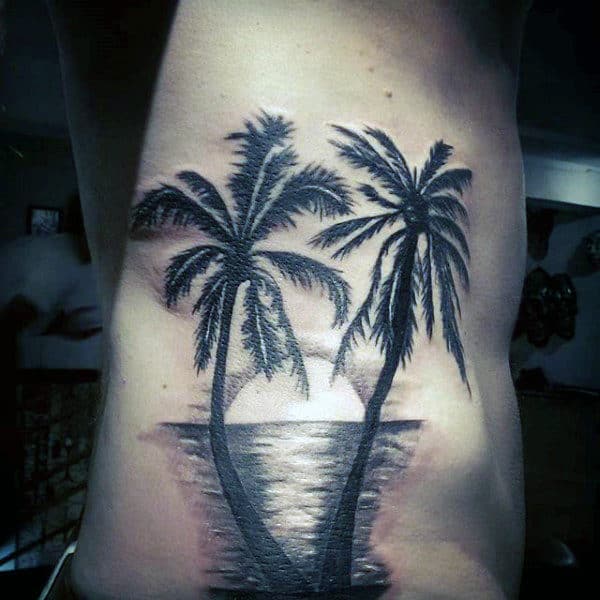 palm trees with sunset reflecting sea tattoo on torso