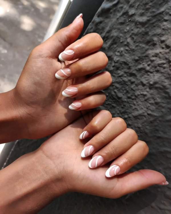 Nude nails with white swirl tips
