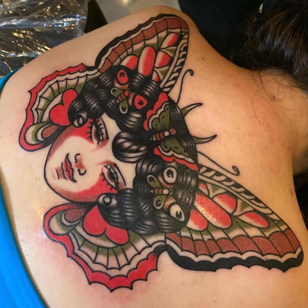 large color japanese tattoo on woman's upper back of a woman's face with butterflies in her hair and wings behind head