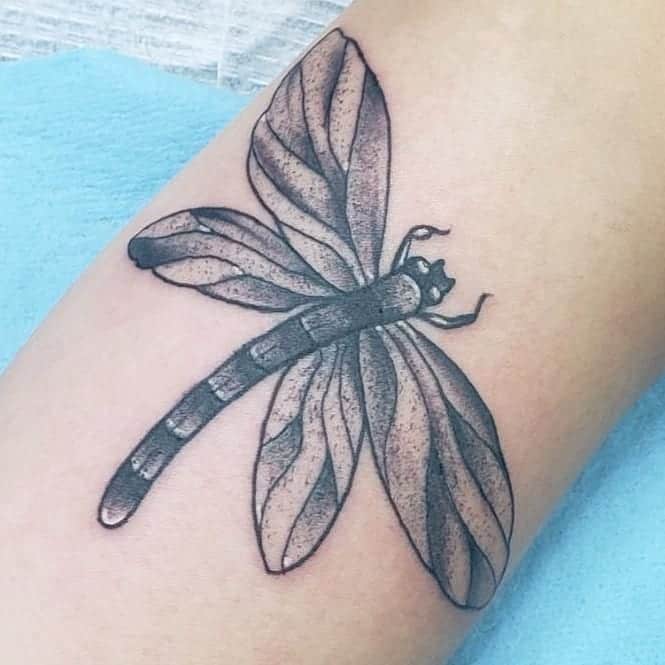 A gigantic dragonfly inked on the arm depicting the "boho" image 