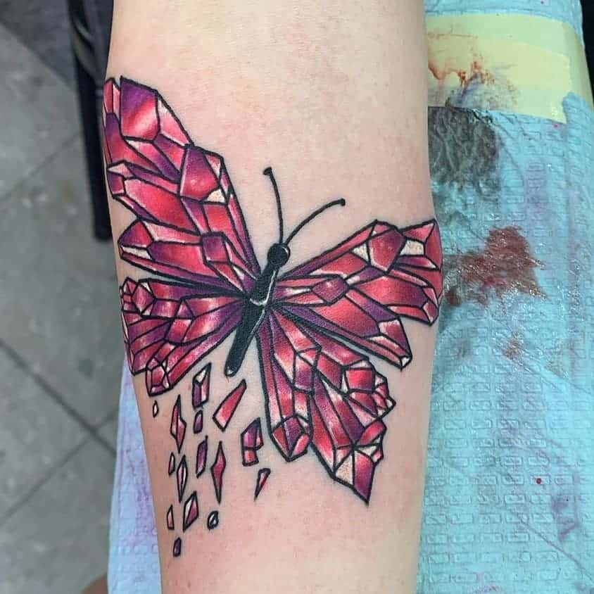 large color geometric tattoo on lower leg of a surrealistic butterfly with wings made of pink crystals