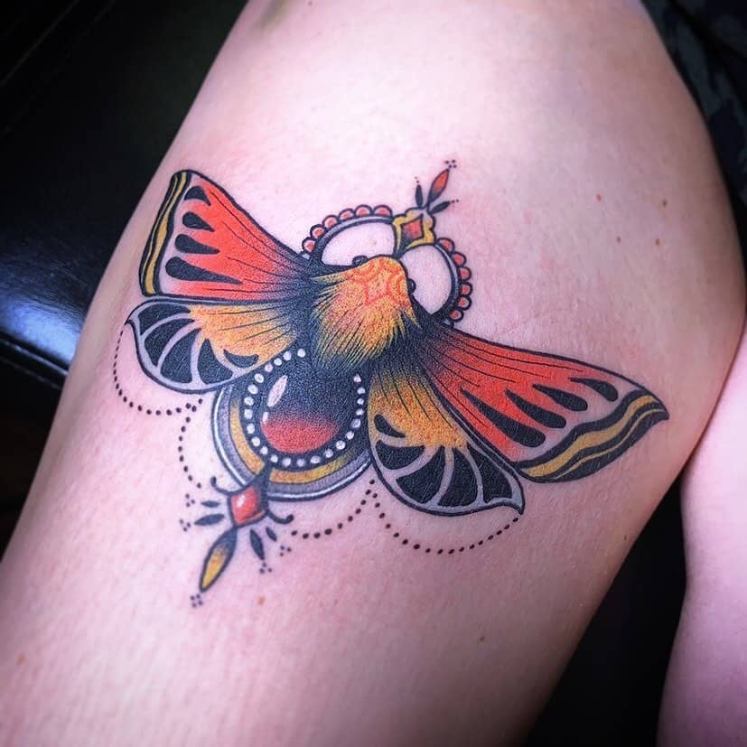 medium-sized traditional color tattoo on woman's lower leg of orange and yellow ornamentalbutterfly