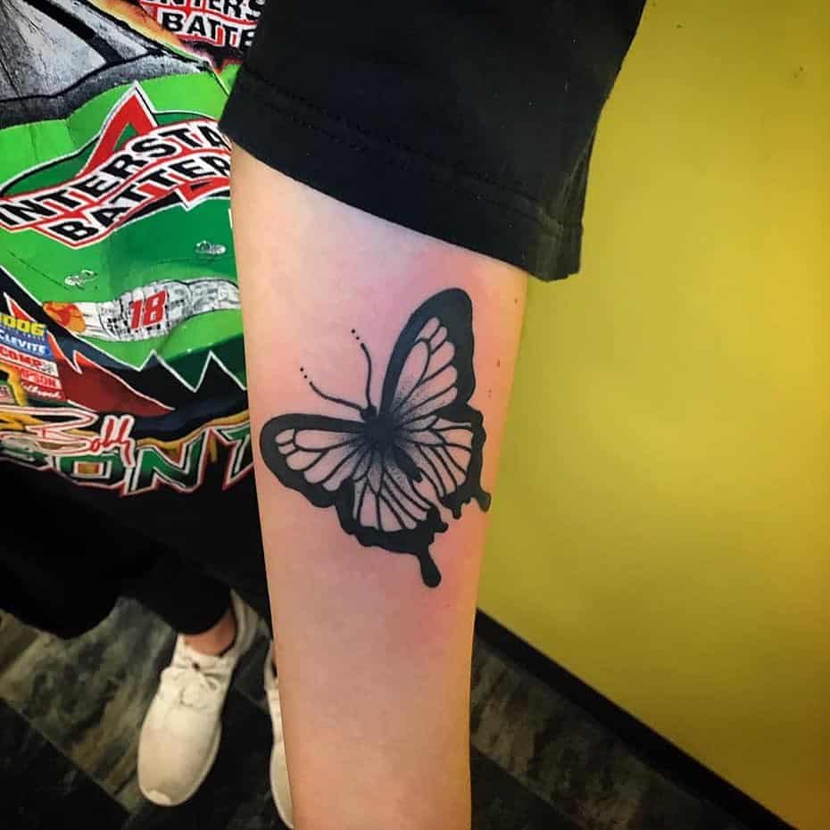 medium-sized black and grey tattoo on man's forearm of realistic butterfly with bold outline