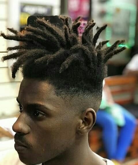A Hi Top Fade Style Featuring Dreadlocks On Top And Faded Sides And Back With Artistic Designs