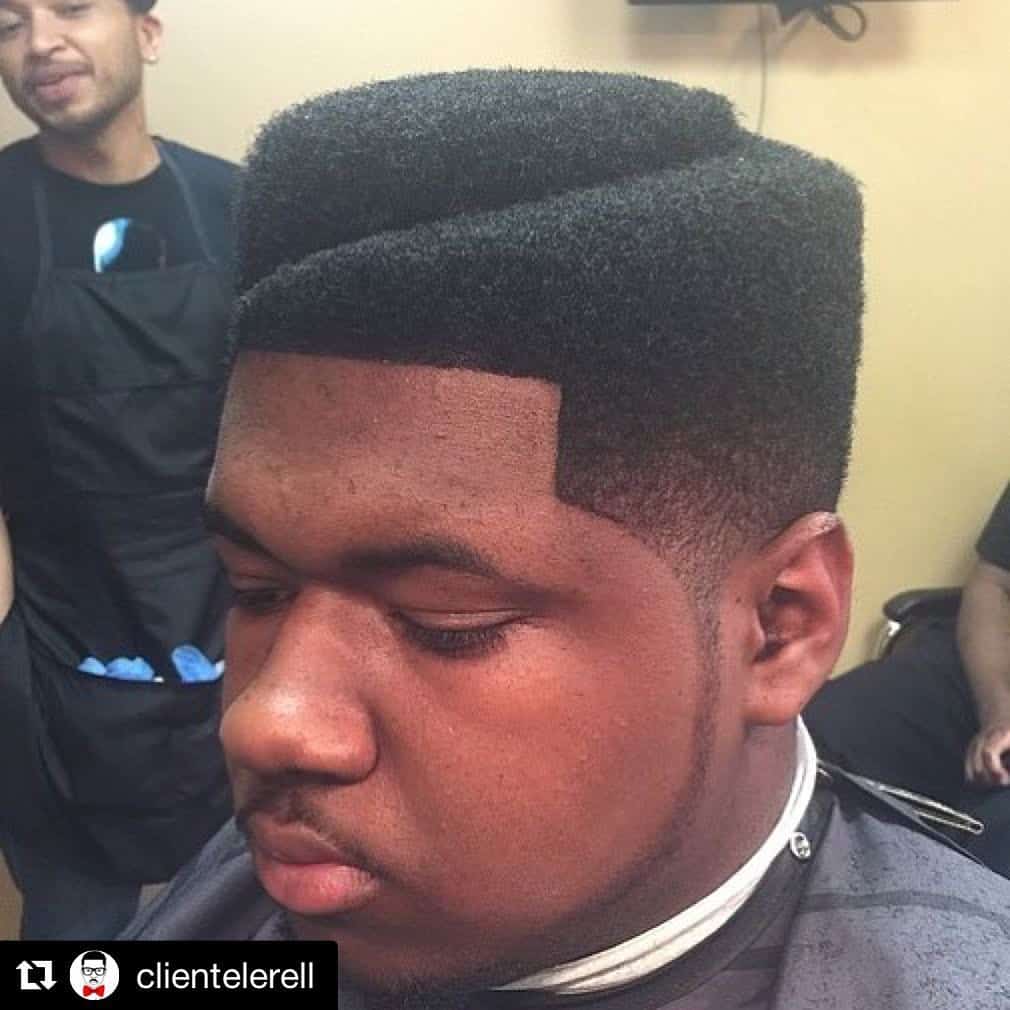 A Hi Top Fade With Hair On Top Sculpted In Different Levels And Paired With A Fade