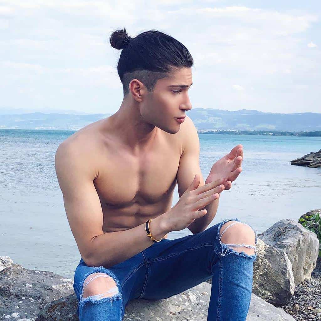 A Man Bun Haircut Featuring A Low Man Bun That Starts Around The Middle Of The Forehead