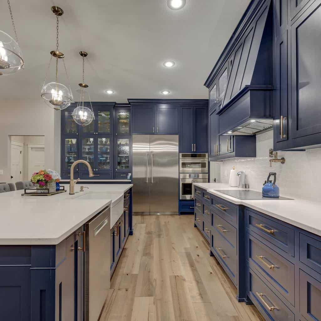 large blue cabinet kitchen white countertops gold accents hardwood floors 