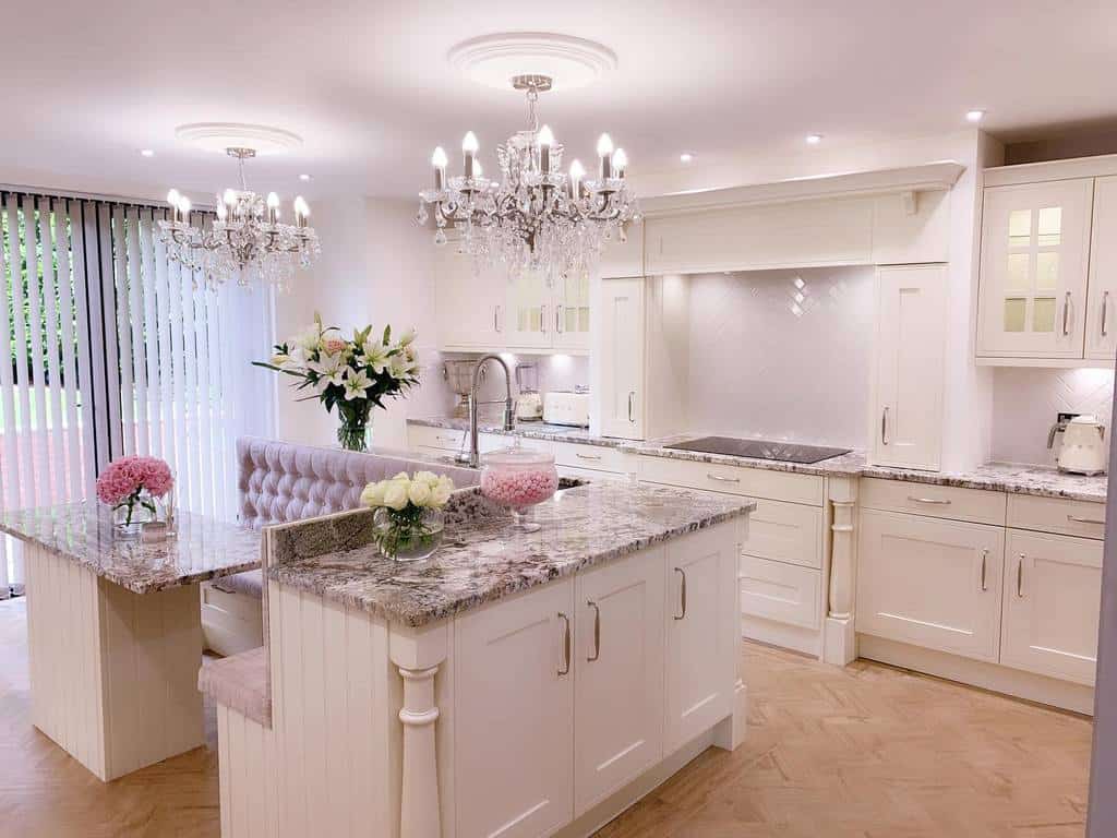 pink and white kitchen marble countertops bench seating two chandeliers