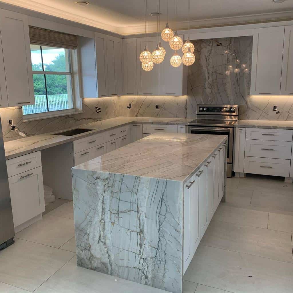 luxury modern kitchen white cabinets gray swirl marble countertops and backsplash pendant lighting 