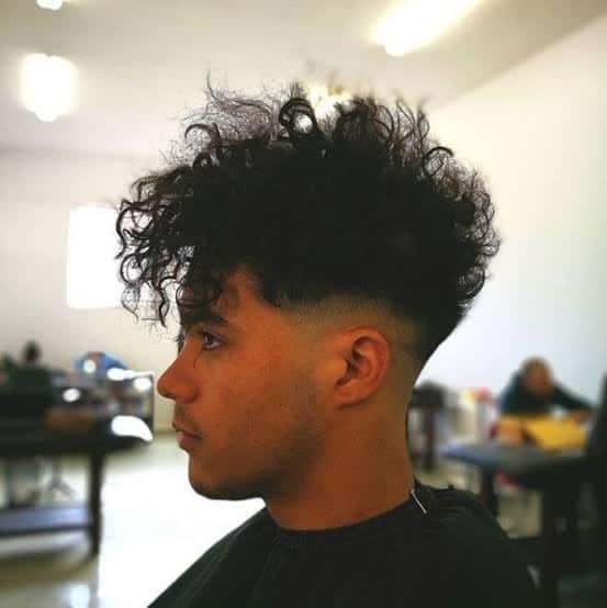 man with curly hair and fohawk hairstyle