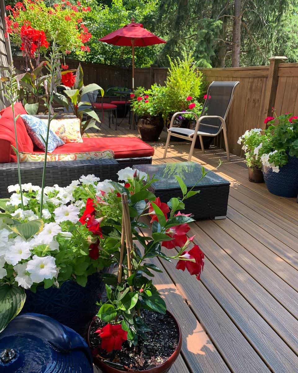 small wood deck backyard wicker lounge chair red umbrella flowers 