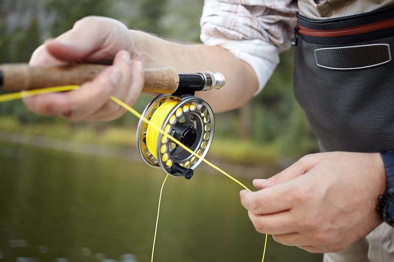 Fly,Fisherman,Using,A,Spinning,Reel,With,Yellow,Line,In