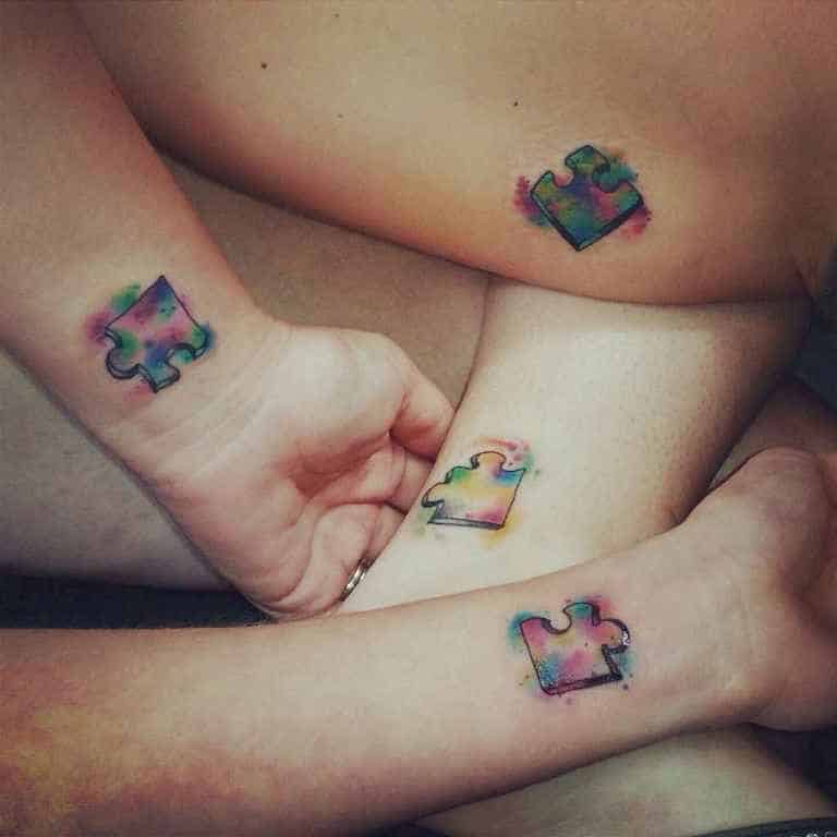 Four matching full color puzzle piece tattoos with watercolor splashes.