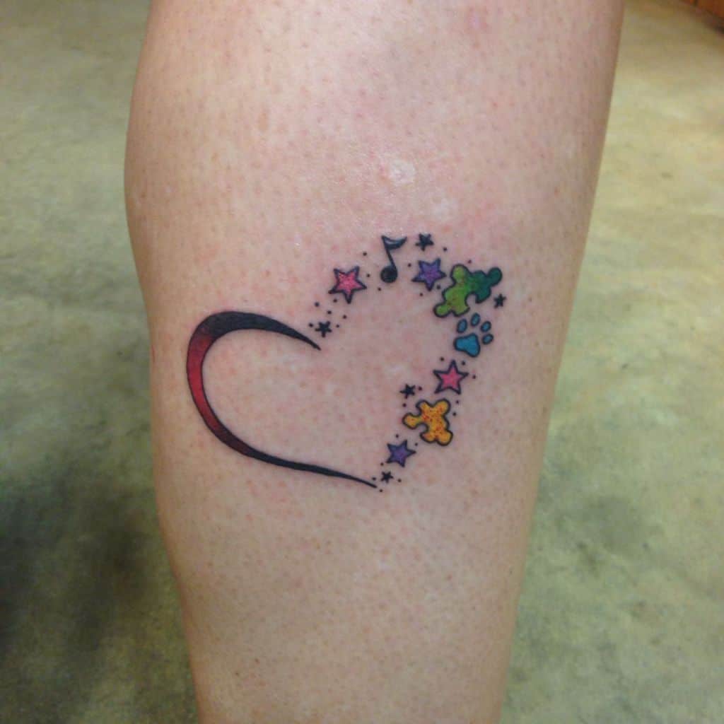 Full color calf tattoo of a heart formed by stars, puzzle pieces, musical notes and swooping line.