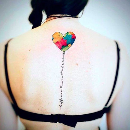: Full color spine tattoo of Autism Awareness Puzzle hear balloon with an inspirational quote as the string.
