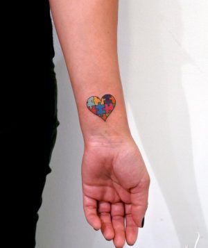 Full color wrist tattoo of an Autism Awareness Puzzle heart.