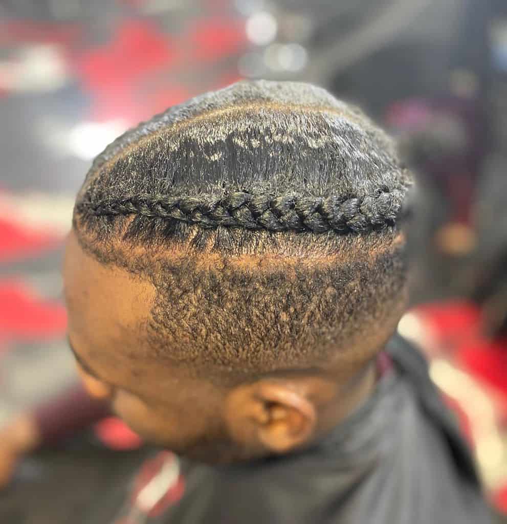 Men’s Cornrows Hairstyle Featuring Two Fine Braids On Top And Bold Detailing Cut Around The Temple