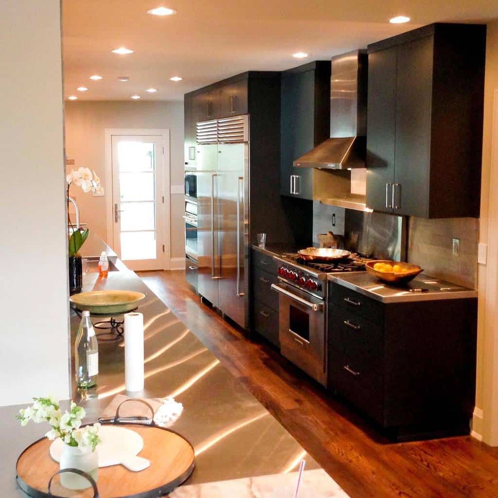 small galley kitchen black cabinets wood flooring 