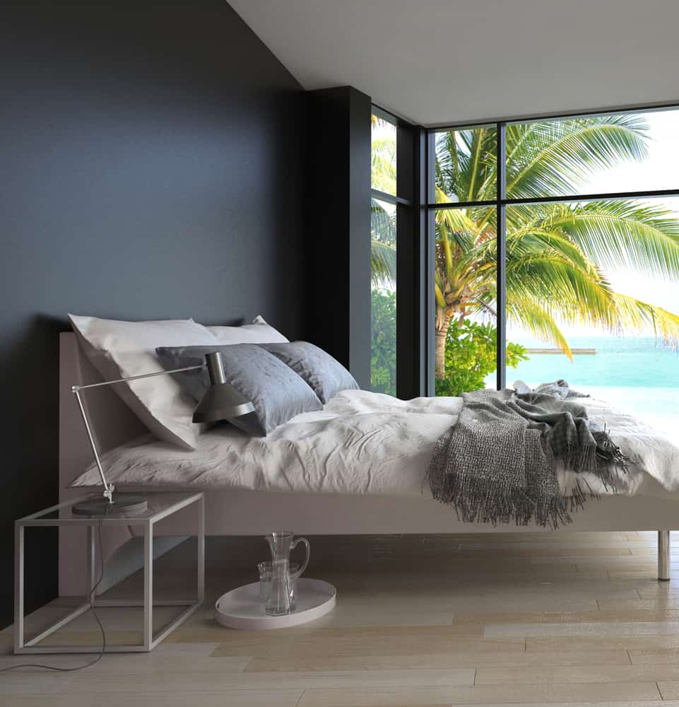 minimalist modern bedroom with black accent wall and ocean view