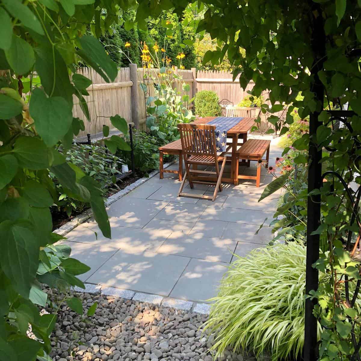 paved backyard wood table and chairs 