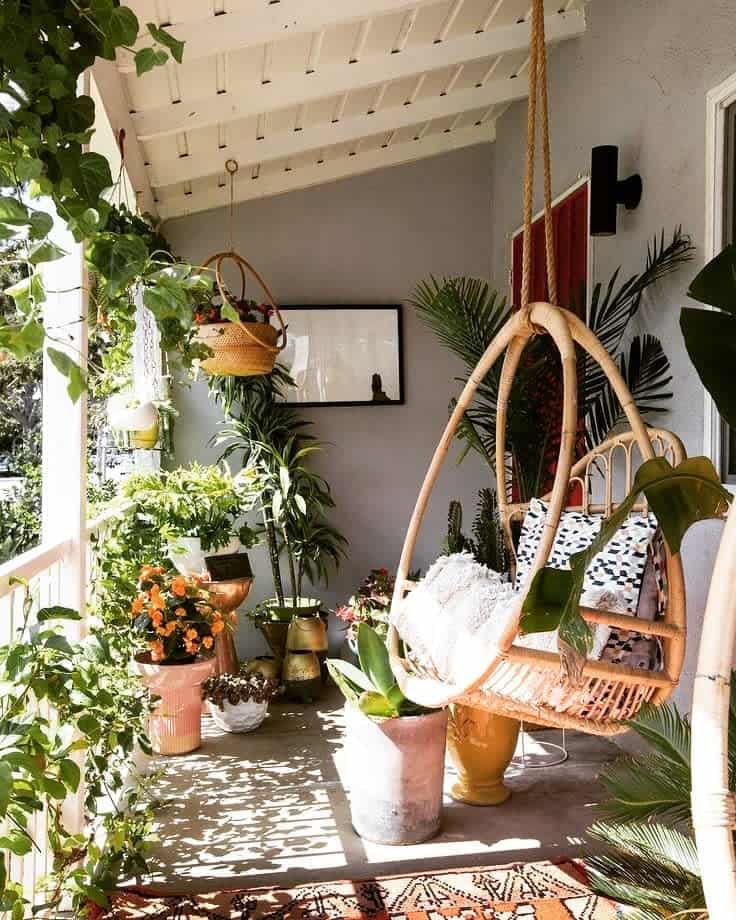 crowded front porch hanging egg chair plants