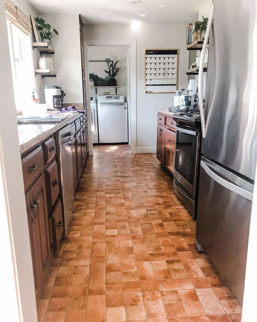 small galley kitchen brown wood cabinets tile flooring 