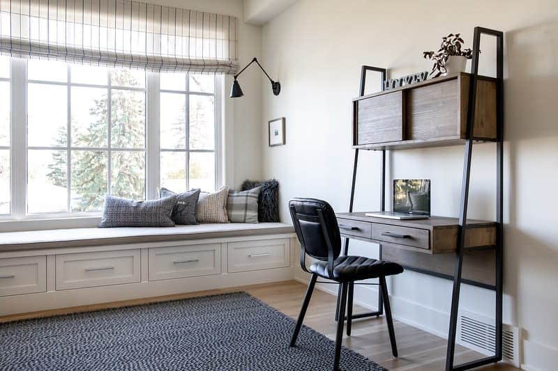 bay window seating in small sunroom with wood desk and black chair