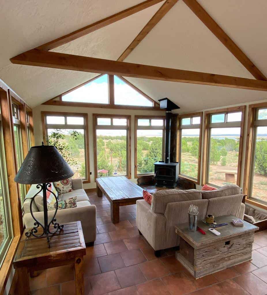 sunroom with gray sofas and tile paver flooring 