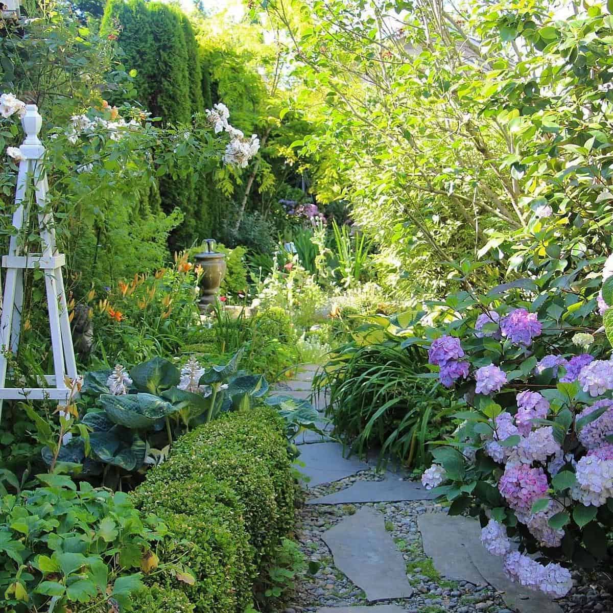 green shrub garden paver path purple flowers