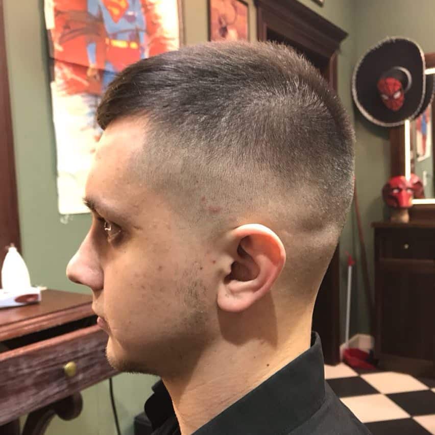 A crew cut style with hair on top swept to one side and paired with faded sides and back