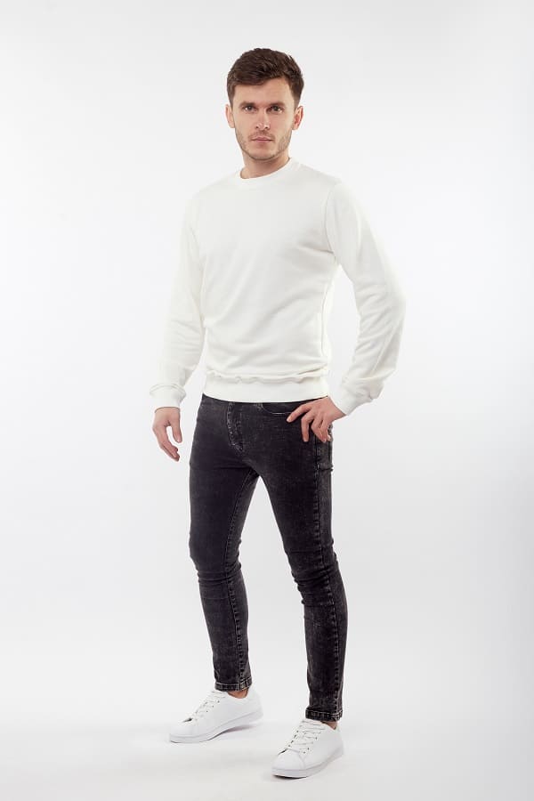 Young,European,Man,In,White,Sweater,And,Black,Pants,Posing