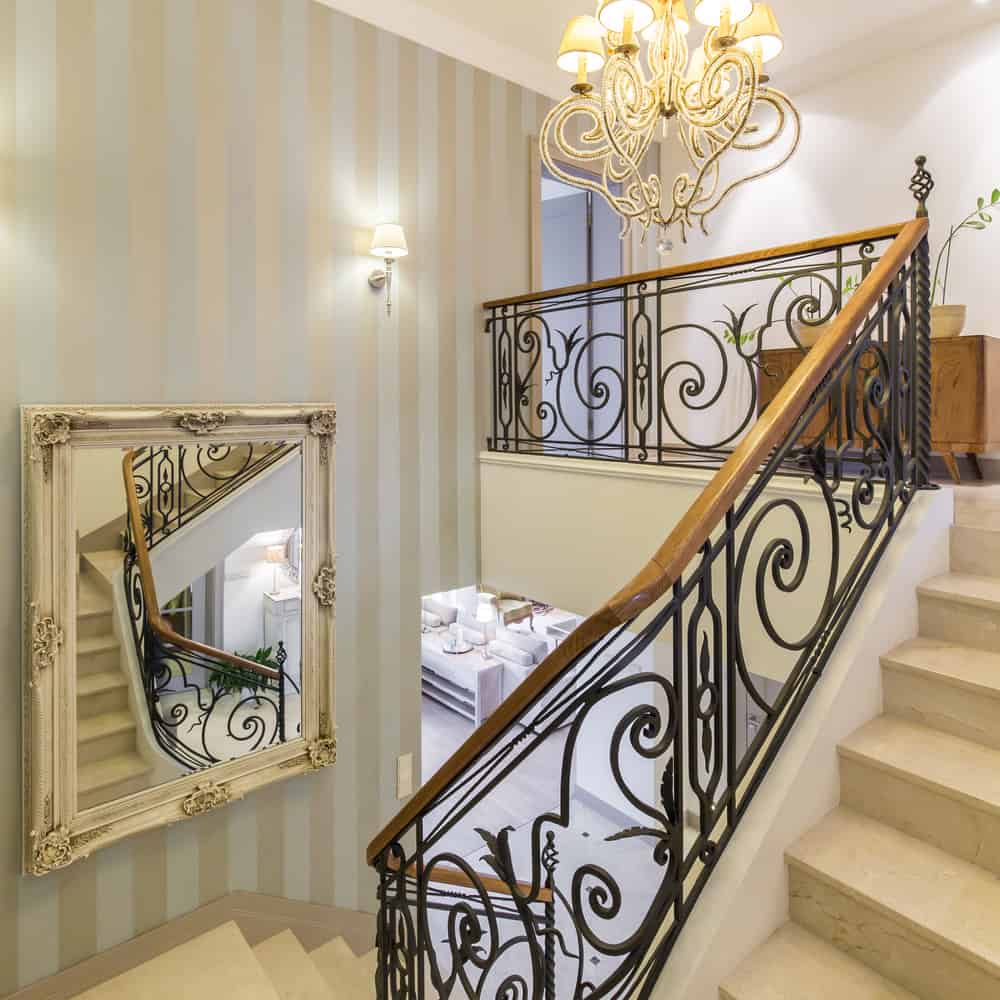 ornate staircase railing with wall mirror 