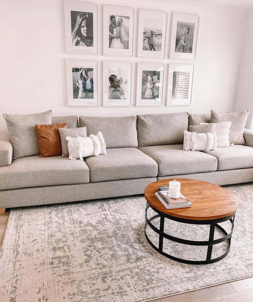 white living room with gray sofa and framed family photos on wall