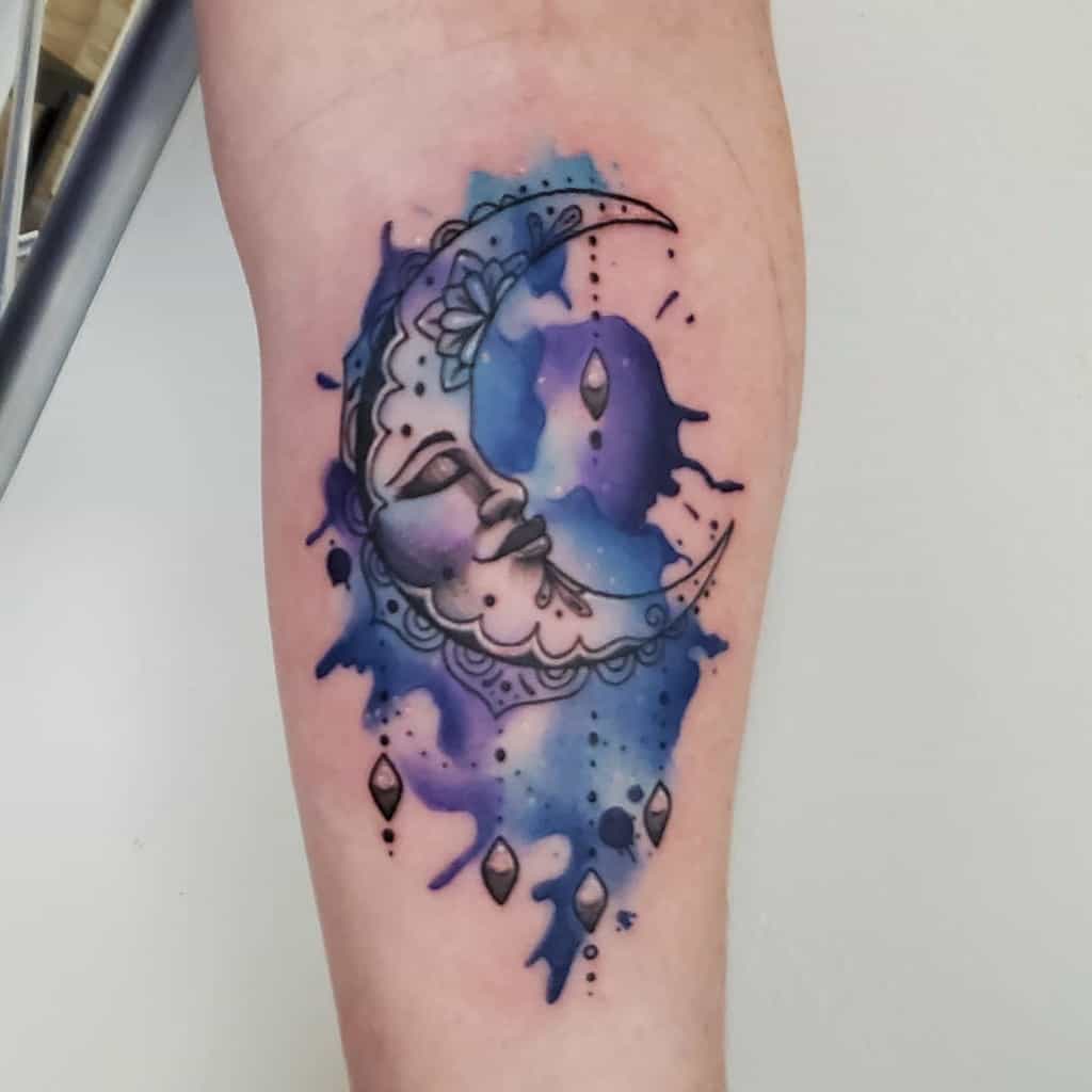 Watercolor style moon tattoo on the inner arm