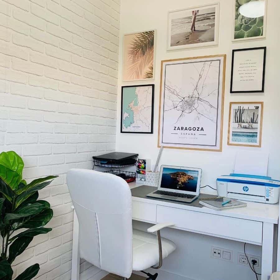 small white office with brick wallpaper and framed wall photos