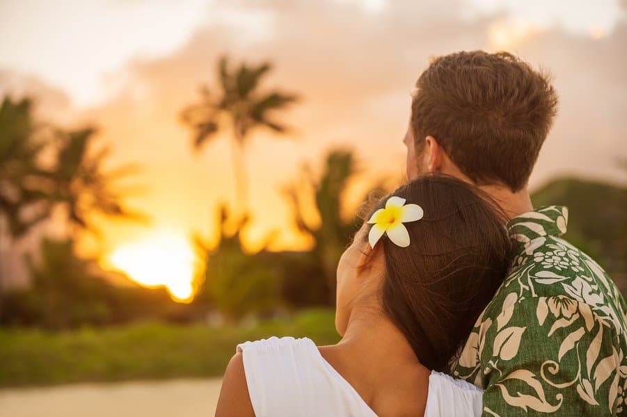 Woman resting head on lover's shoulder on honeymoon vacation travel in summer Hawaii destination