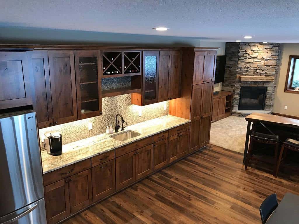 large wood kitchen silver fridge floorboards stone fireplace