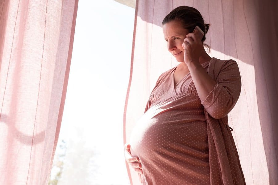 Young pregnant woman calling on the phone