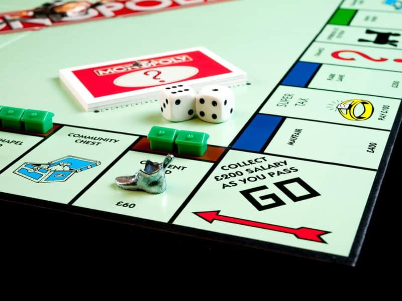 Monopoly board with dice, cards, houses, GO space, and metal shoe—classic fun that goes beyond mobile games or typical action shooters for men