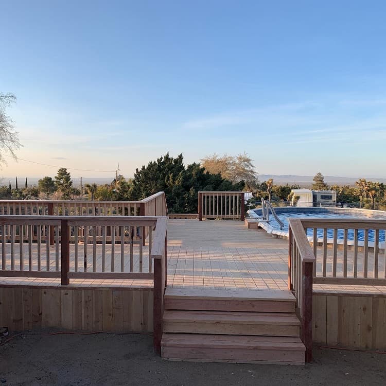 wood deck above ground pool with view