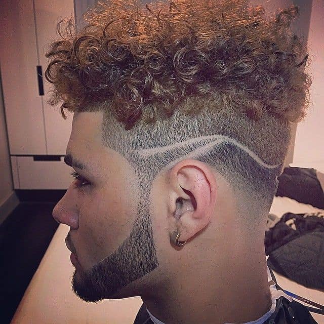 Curly top hair with faded sides and artistic lines on the sides
