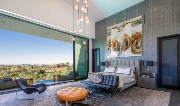 large luxury bedroom with window that opens onto balcony 