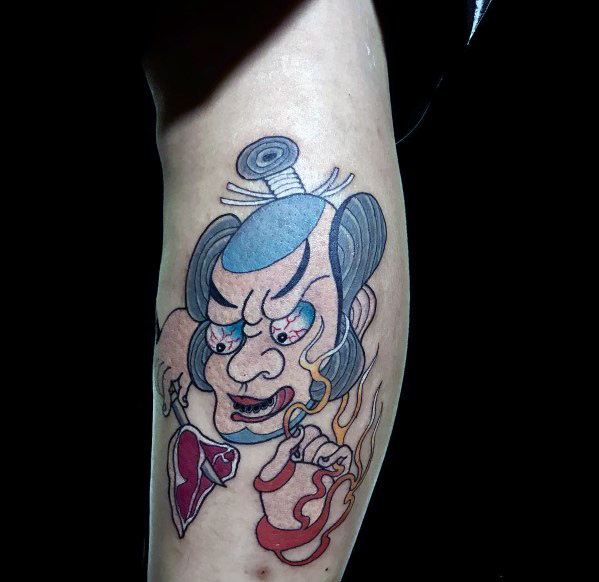 Tattoo of a traditional Japanese warrior with a fierce expression, holding a fork with a piece of steak, surrounded by dynamic flames