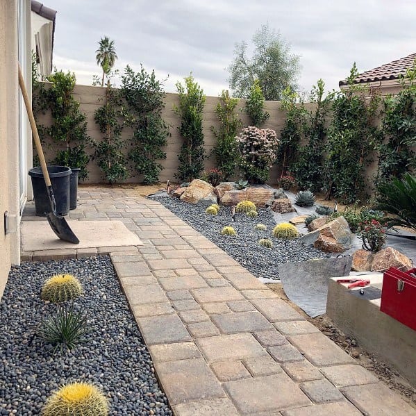 stone paver walkway rocky backyard garden with cactus 