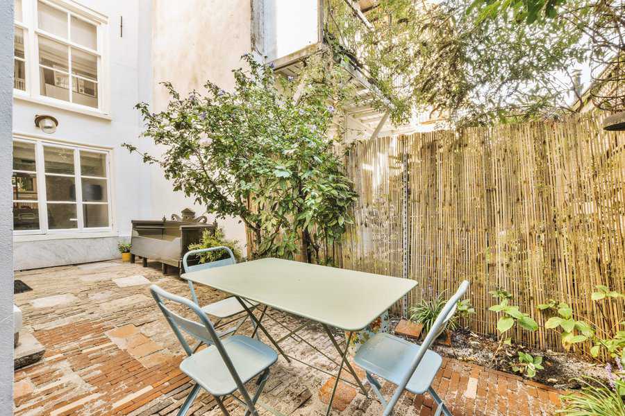 outdoor patio with table and chairs bamboo fence 