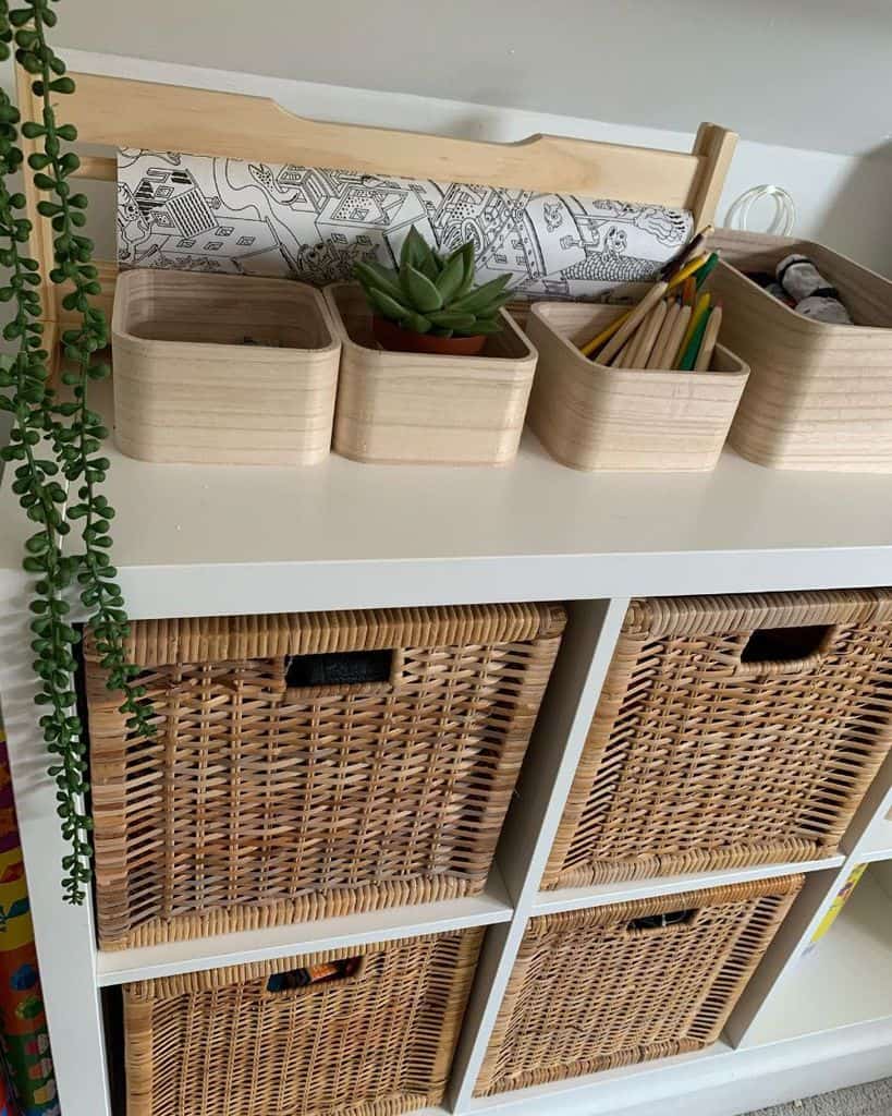 White storage unit with wicker baskets, wooden bins, and a small plant.