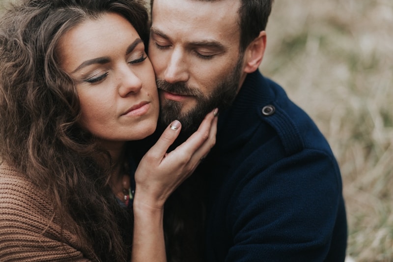 bearded man hugging curly woman outdoor