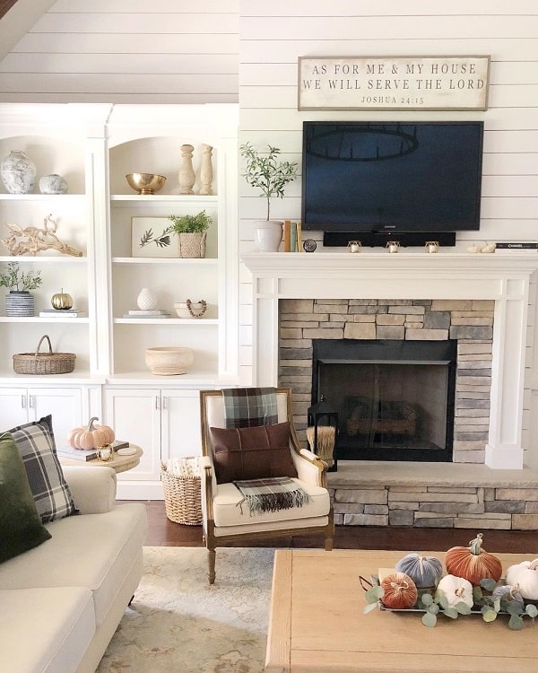 beautiful cozy stone fireplace white shiplap walls cabinet with shelves 