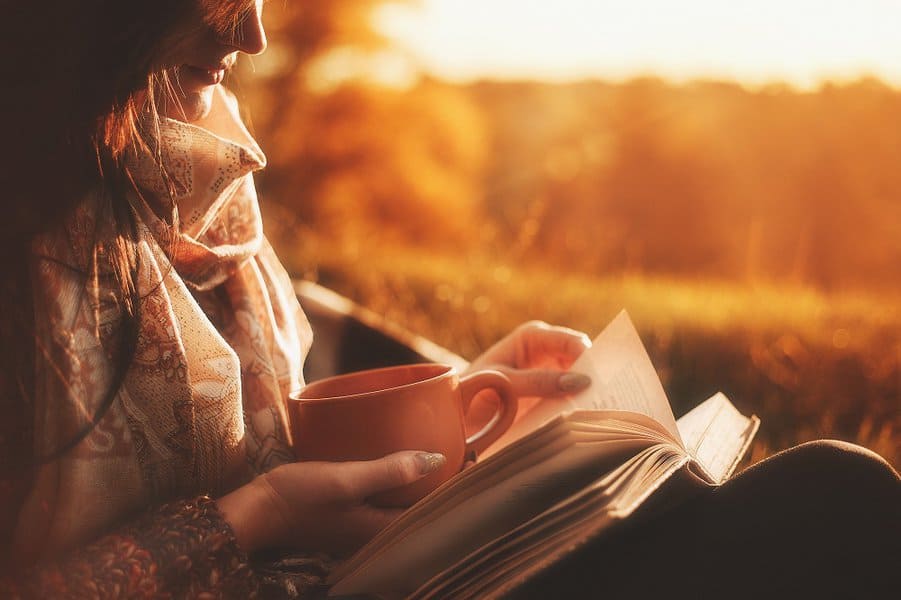 beautiful woman reading book in a autumn forest